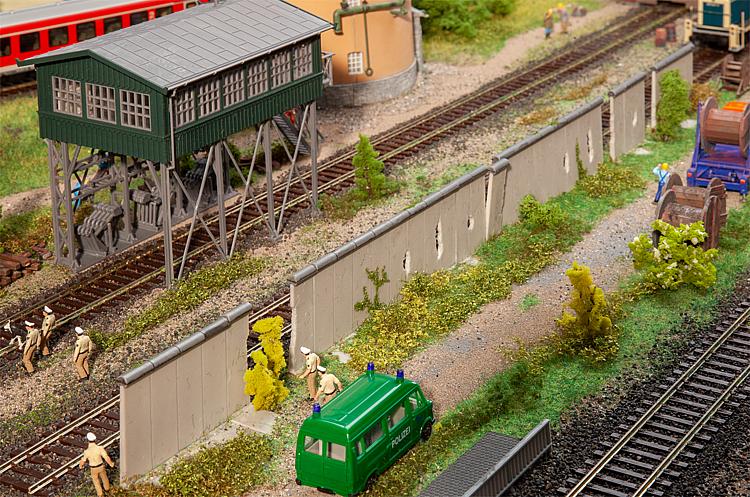 H0 Betonmauer ; Betonelemente mit Sockel und einem runden, oberen Abschluss für den Bau einer hohen Mauer. Einzelne Elemente enthalten Mauerlöcher.